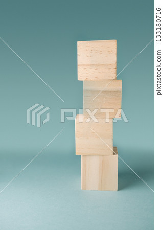 Stacked wooden blocks on a soft blue background showcasing balance and creativity in design 133180716