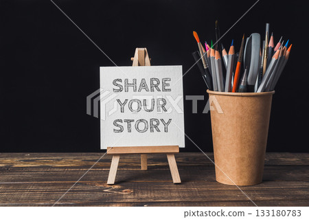 Creative workspace with easel displaying motivational message and colorful art supplies nearby 133180783