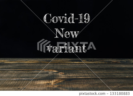 Covid-19 new variant text displayed on a wooden table with dark background for informative purposes 133180883