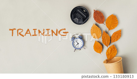 Training concept with autumn leaves, clock, and coffee cup on a neutral background Training concept with autumn leaves, clock, and coffee cup on a neutral background 133180913