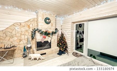 Cozy living room decorated for holidays with a Christmas tree, stockings, and a fireplace, creating a warm and inviting atmosphere for festive gatherings Cozy living room decorated for holidays with a Christmas tree, stockings, and a fireplace, creating a warm and inviting atmosphere for festive gatherings 133180974