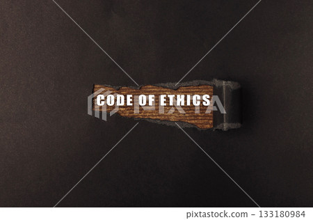 Wooden sign displaying the phrase "Code of Ethics" on a dark textured background 133180984