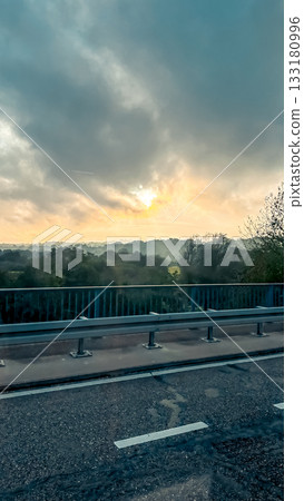 Scenic view of a tranquil landscape at sunrise, with soft clouds and trees silhouetted against a colorful sky, creating a serene atmosphere of nature Scenic view of a tranquil landscape at sunrise, with soft clouds and trees silhouetted against a colorful sky, creating a serene atmosphere of nature 133180996
