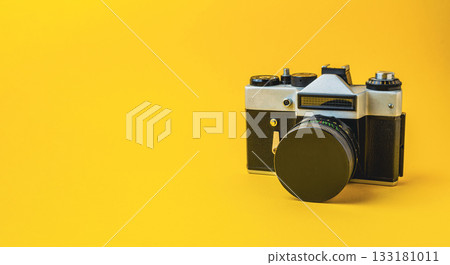 Vintage camera on a bright yellow background, showcasing classic design and photography elements Vintage camera on a bright yellow background, showcasing classic design and photography elements 133181011