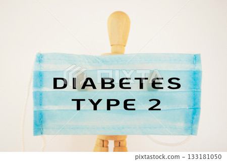 Wooden mannequin holding a blue medical mask with text about diabetes type 2 awareness 133181050