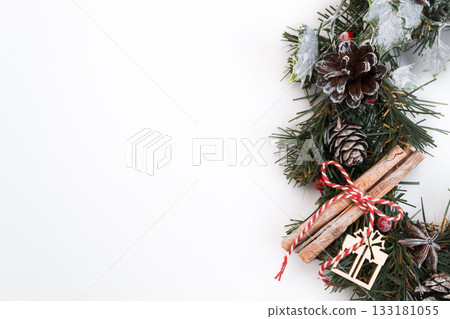 Festive Christmas wreath with pinecones, cinnamon sticks, and decorative elements on white background 133181055