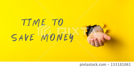 Hand emerging from yellow wall with message about saving money and financial awareness Hand emerging from yellow wall with message about saving money and financial awareness 133181061