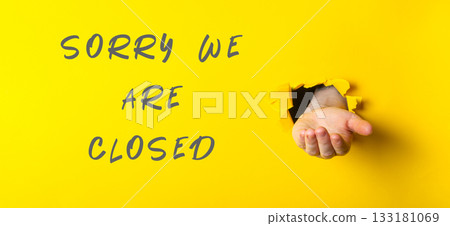 Sorry we are closed sign with a hand holding a hole in it Sorry we are closed sign with a hand holding a hole in it 133181069