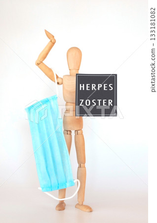 Man holding a blue face mask with the words Herpes Zoster 133181082