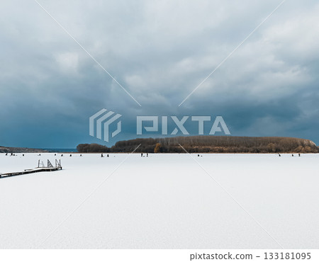 Serene winter landscape with frozen lake, cloudy sky, and distant forested island view Serene winter landscape with frozen lake, cloudy sky, and distant forested island view 133181095