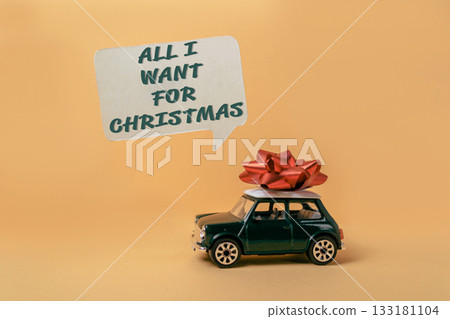 Miniature car with red bow on top, symbolizing Christmas gift wishes and holiday cheer 133181104