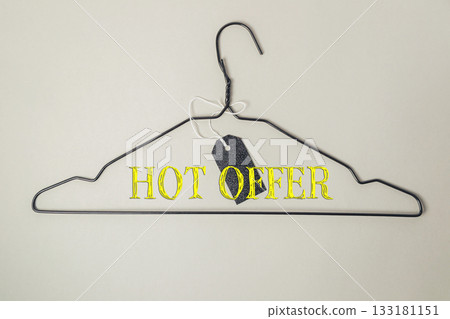Wire hanger with bold text displaying hot offer and a price tag attached for promotional purposes Wire hanger with bold text displaying hot offer and a price tag attached for promotional purposes 133181151
