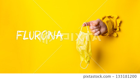 Person holding a yellow mask with the word Fluorna written in white Person holding a yellow mask with the word Fluorna written in white 133181200