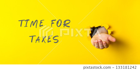 Hand emerging from yellow background with text indicating tax season and financial awareness Hand emerging from yellow background with text indicating tax season and financial awareness 133181242