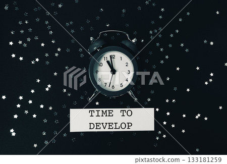 The clock lies on a dark background with glitter and Spitch bubbles. 133181259