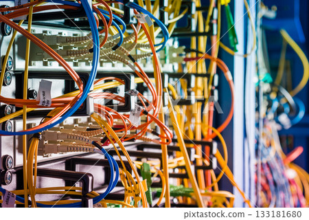 Server rack with fiber optic cables attached to front panel swit Server rack with fiber optic cables attached to front panel swit 133181680