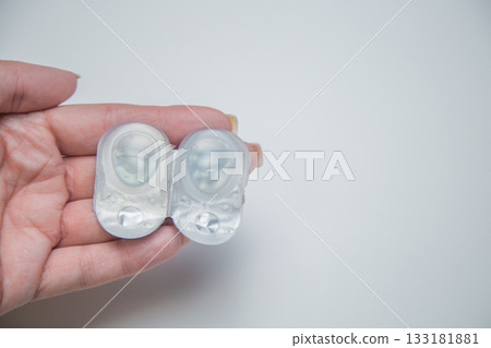 A close-up of one-day contact lenses in disposable protective packaging on a white background with space for text lie in the palm of your hand. The concept of eye moisturizing, ophthalmology, vision 133181881