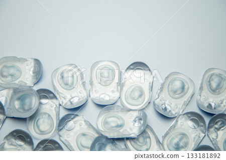 Many daily contact lenses in a disposable protective case lie at the bottom on a white background with space for text. The concept of ophthalmology, vision correction, eye care. High quality photo Many daily contact lenses in a disposable protective case lie at the bottom on a white background with space for text. The concept of ophthalmology, vision correction, eye care. High quality photo 133181892