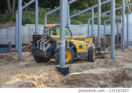 Telescopic handler at a construction site. Construction equipment for loading. Front-end loader for lifting loads, a forklift at a construction site, construction work. Telescopic handler at a construction site. Construction equipment for loading. Front-end loader for lifting loads, a forklift at a construction site, construction work. 133181927