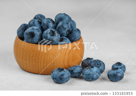 Fresh ripe blueberries in wooden bowl on light gray stone background closeup macro healthy food Fresh ripe blueberries in wooden bowl on light gray stone background closeup macro healthy food 133181953