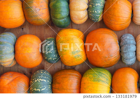 Stacked pumpkins in green and orange colors forming decorative wall, autumn harvest background Stacked pumpkins in green and orange colors forming decorative wall, autumn harvest background 133181979