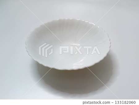 Empty White Deep Plate with Wavy Edge on Light Background Empty White Deep Plate with Wavy Edge on Light Background 133182060