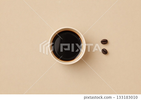 Warm cup of coffee and coffee beans on beige background 133183010