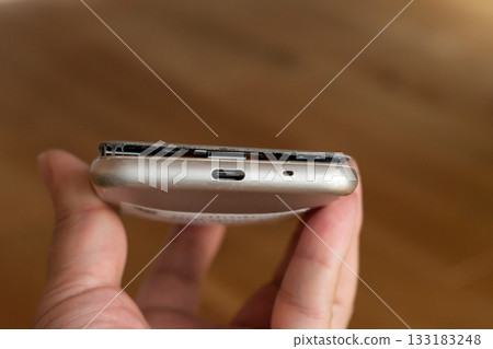 Man holding smartphone with swollen mobile battery 133183248