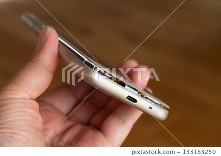 Man holding smartphone with swollen mobile battery Man holding smartphone with swollen mobile battery 133183250