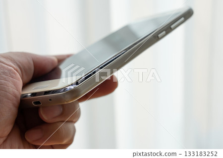 Man holding smartphone with swollen mobile battery Man holding smartphone with swollen mobile battery 133183252