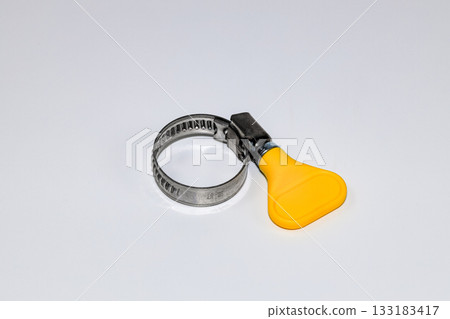 Steel Worm Gear Hose Clamp with yellow thumb screw key, Screw clamp or Hose clamps or Steel clamps isolated on white background. Steel Worm Gear Hose Clamp with yellow thumb screw key, Screw clamp or Hose clamps or Steel clamps isolated on white background. 133183417