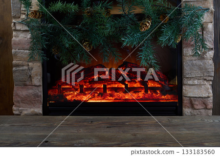 Cozy Fireplace. A warm, decorative fireplace with evergreen branches and pinecones. Cozy Fireplace. A warm, decorative fireplace with evergreen branches and pinecones. 133183560
