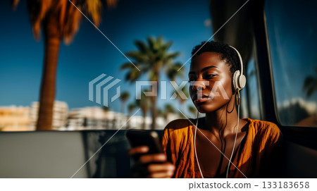 portrait of a young African American woman riding a bus enjoying her favorite music using a smartphone, cinematic shot of a young woman listening to her favorite podcasts on her way to work 133183658