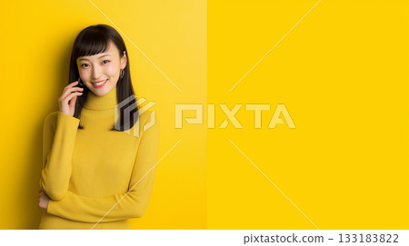 A woman creates a frame with her hands on a yellow background 133183822