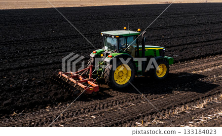 Seasonal farm work: a tractor plowing the soil before planting winter crops, growing organic crops, and the importance of farmers' work 133184023