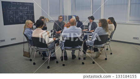 Diverse Group of Adult Students Sits in Circle Inside Modern Classroom 133184155