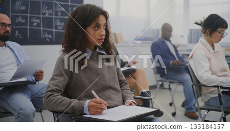 Young Woman in Good Mood Among Group Adult Students of Various Ages Completing Written Test 133184157