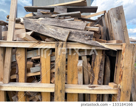 A pile of used broken lumber is stacked at a construction site A pile of used broken lumber is stacked at a construction site 133184166