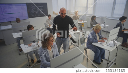 In Tech Classroom, Multicultural Group of Adult Learners Focus on Computers 133184185