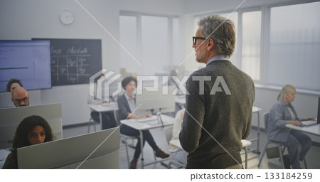 Stylish Mature Man Instructor Conducts IT Lecture, Encouraging Adult Students Engage in Discussion 133184259