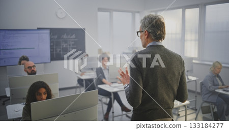Stylish Mature Man Instructor Conducts IT Lecture, Encouraging Adult Students Engage in Discussion 133184277