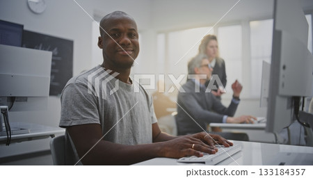 Cheerful Man Attends Programming Class, Smiling Brightly While Working on Computer 133184357
