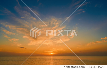 view of the autumn sea and the sunset among beautiful clouds, warm and mild weather of the autumn season at sea, a poster for advertising cosmetics from environmentally friendly natural components 133184520