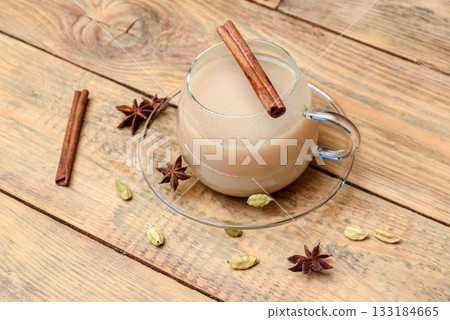 Masala tea in a glass mug with a cinnamon stick. 133184665