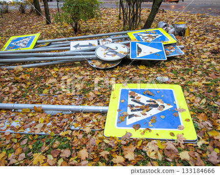 Road signs lie on the ground covered with autumn leaves. Road signs lie on the ground covered with autumn leaves. 133184666