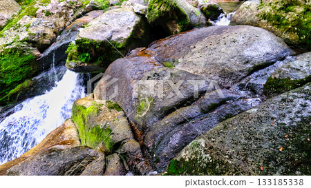 一條溪流流經崎嶇的岩石 一條溪流流經崎嶇的岩石 133185338