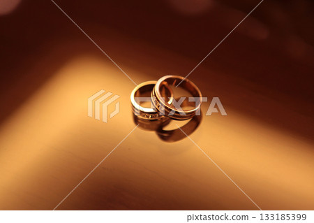 Elegant precious Diamond wedding Rings Resting On Surface With Blurred Backdrop For Wedding ceremony 133185399