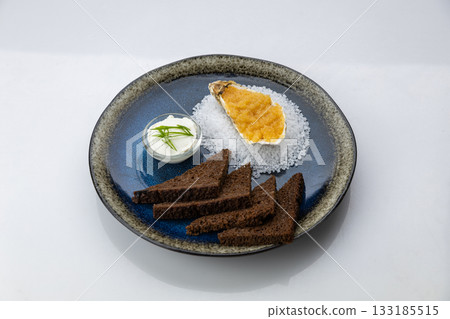 Oyster with caviar, rye toasts and sour cream on black plate, top view 133185515