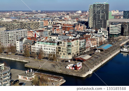 Antwerp Eilandje district aerial view, a vibrant urban landscape combining old and new architecture along the harbor canal Antwerp Eilandje district aerial view, a vibrant urban landscape combining old and new architecture along the harbor canal 133185588