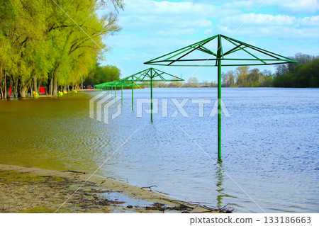 Empty beach awnings flooded with water during flood of spring Empty beach awnings flooded with water during flood of spring 133186663